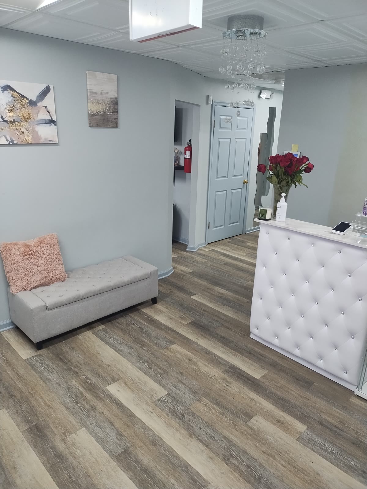 Back salon lounge space with seating, framed art, and hardwood floors