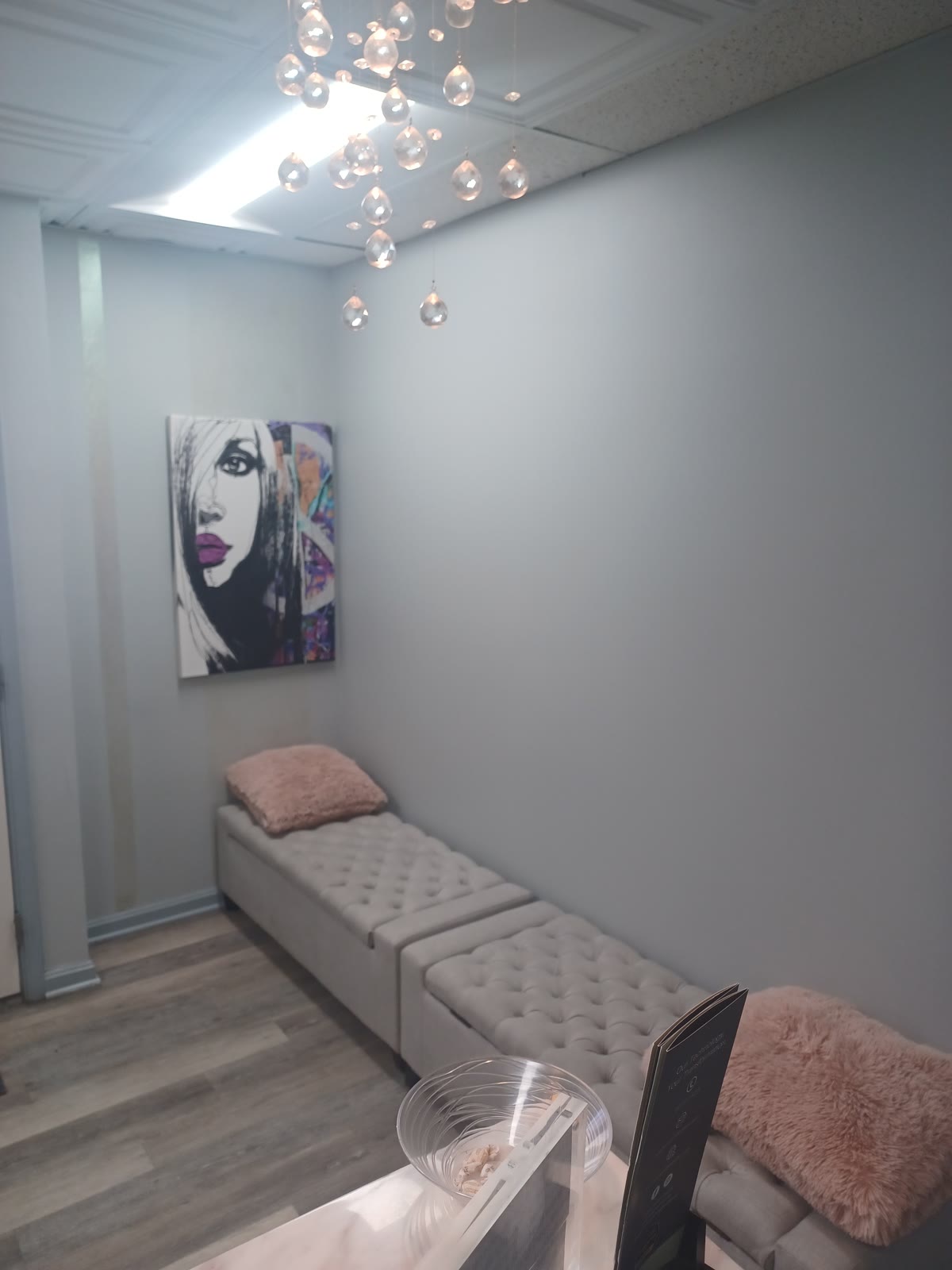 Comfortable salon seating area with modern artwork under a crystal chandelier